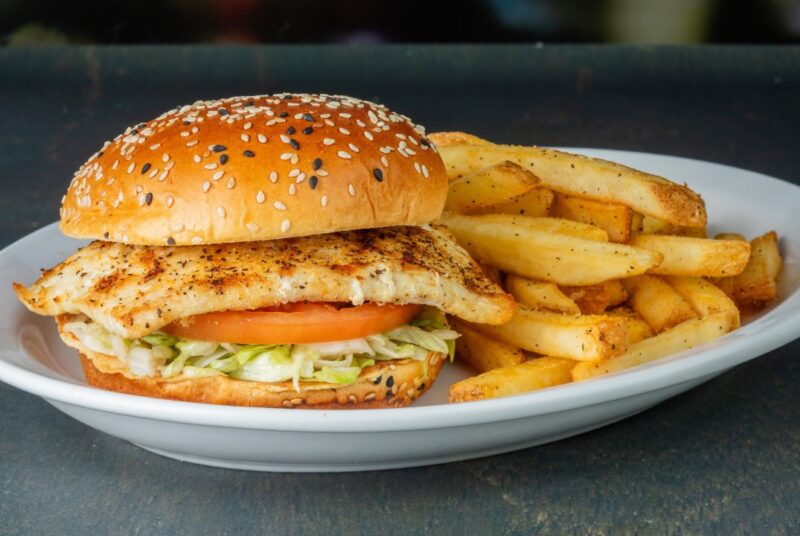 mahi mahi sandwich on a plate with fries from millers ale house